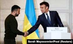 Президент України Володимир Зеленський (ліворуч) і президент Франції Емманюель Макрон потиснули один одному руки під час спільної заяви з канцлером Німеччини Олафом Шольцем. Париж, 8 лютого 2023 року