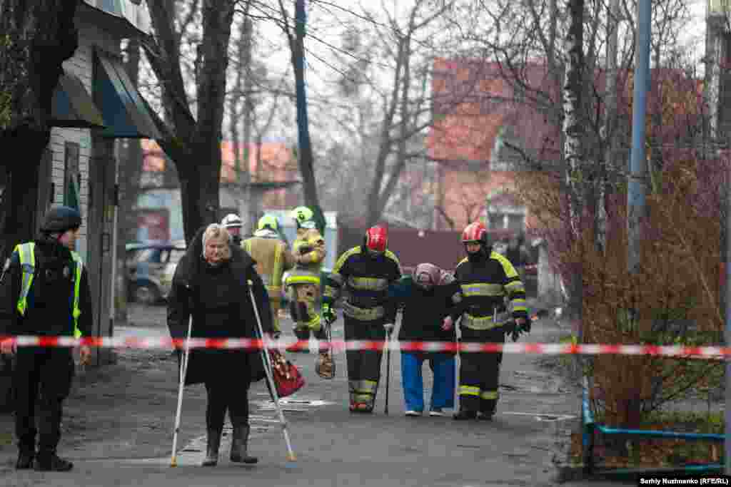 First responders help residents leave their homes following the missile attack.