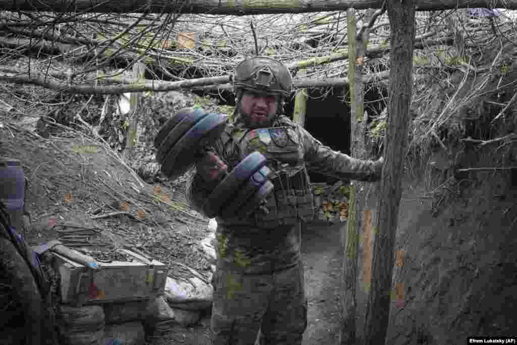 Український військовий, стоячи в окопі, піднімає важку гантель. Каже, що бійці стільки часу тримають цю позицію під Бахмутом, що почали вже називавати це місце «домом». Донеччина, Україна. 3 березня 2024 року 