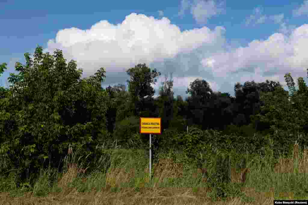 A sign in Polish warns that the Belarusian border is close by, near the Bug River on July 20. On the Polish side of the border around the village of Kolpin-Ogrodniki, Reuters journalists reported hearing gunfire coming from Belarusian territory on July 20. 