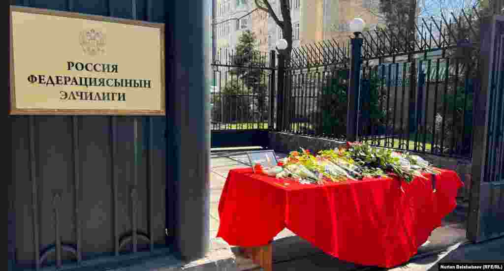 Эскерүү иш-чарасы Кыргызстандын борбор калаасында да өтүп жатат. Бишкектеги Орусиянын элчилигинин имаратынын астына шаардыктар гүл коюп жатышат. 23-март, Бишкек, Кыргызстан. 