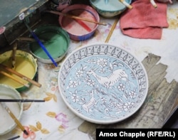 A partially painted plate in the Balian workshop.