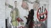 Studentica umjetnosti slika mural protiv korupcije na ulici u Lahoreu, Pakistan, novembar 2023.