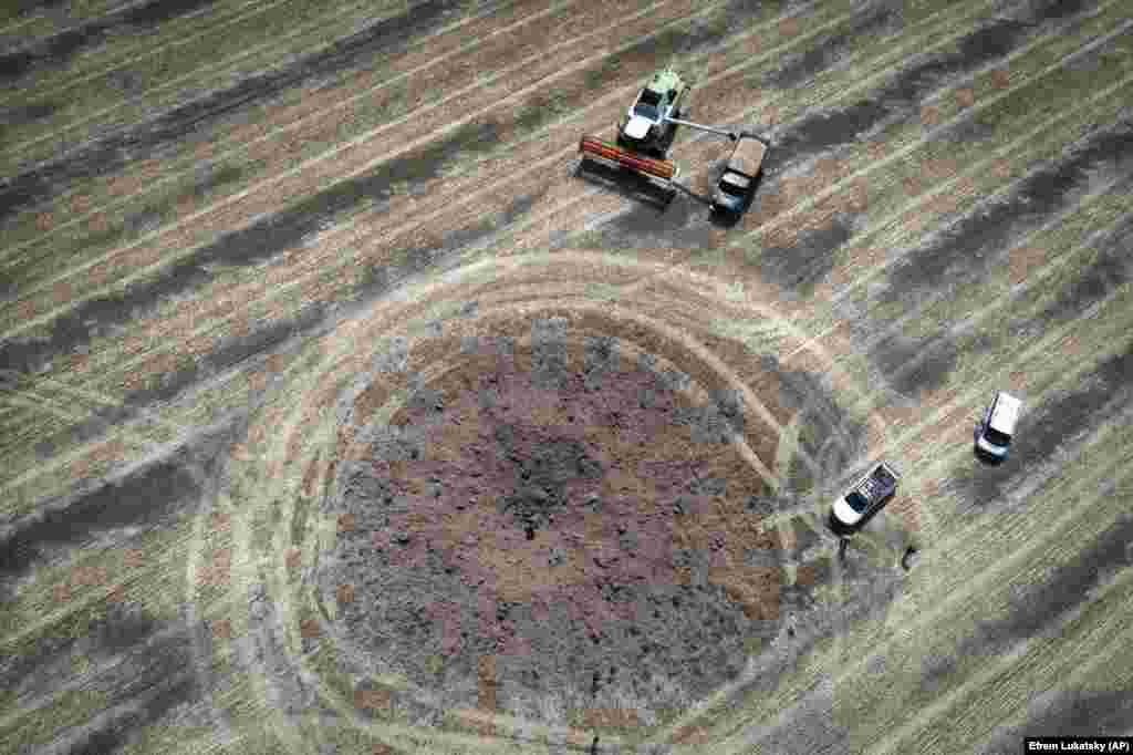 Fermierii recoltează în jurul unui crater lăsat de o rachetă rusească. Din cauza blocadei porturilor, pe lângă pericolele reprezentate de muniția neexplodată care le acoperă câmpurile și a scăderii forței de muncă pe măsură ce bărbații apți de muncă merg pe front, mulți dintre fermierii ucraineni se străduiesc să ofere produsele lor celor din țările în curs de dezvoltare care se luptă cu foamea.