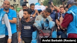 یو خبریال د اکتوبر پر ۱۰مه په اسراییل برید کې د وژل شوي همکار په وینو رنګ جاکټ په لاس کې نیولی دی.