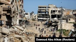 Palestinci hodaju između ruševina u gradu Gaza, 20 mart 2024.