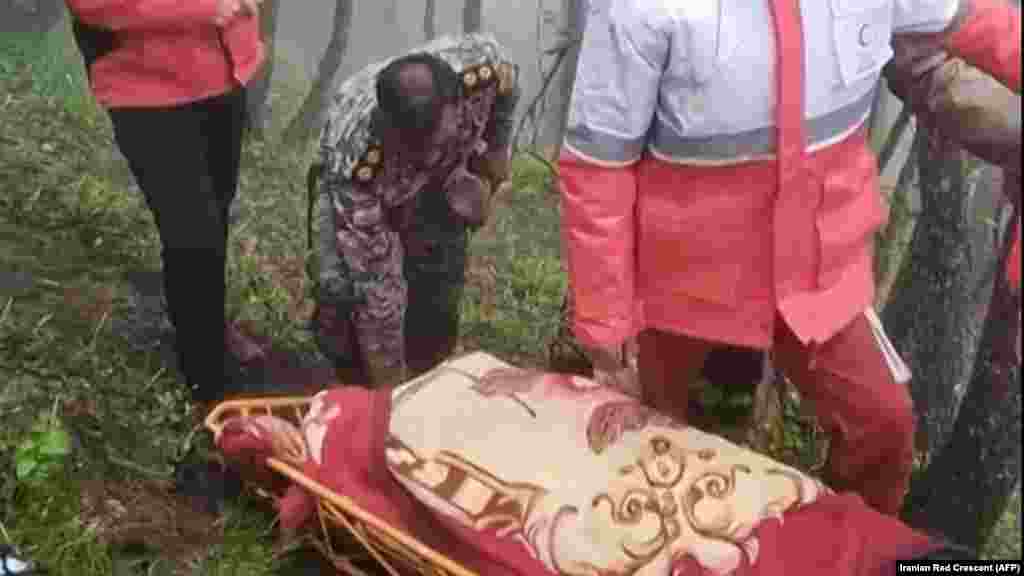 A video grab shows rescuers recovering bodies at the crash site. 