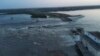 Кадр із відео наслідків руйнування дамби Каховської ГЕС, опублікованого 6 червня 2023 року президентом Зеленським. Влада Уrраїни звинуватила російську армію у підриві машинного залу гідроелектростанції зсередини. Натомість окупаційна адміністрація звинувачує ЗСУ