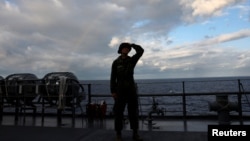 A Japanese soldier stands on the flight deck of a Japanese amphibious transport ship in waters close to Okinawa, Japan, on November 15.