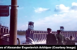 Nazi troops watch water surge through the dam.