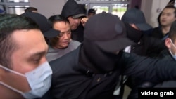 Surrounded by security officers, Raimbek Matraimov appears at a courthouse in Bishkek on March 27.