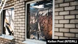 Window on an interior scarred from heat and shrapnel, Kharkiv.