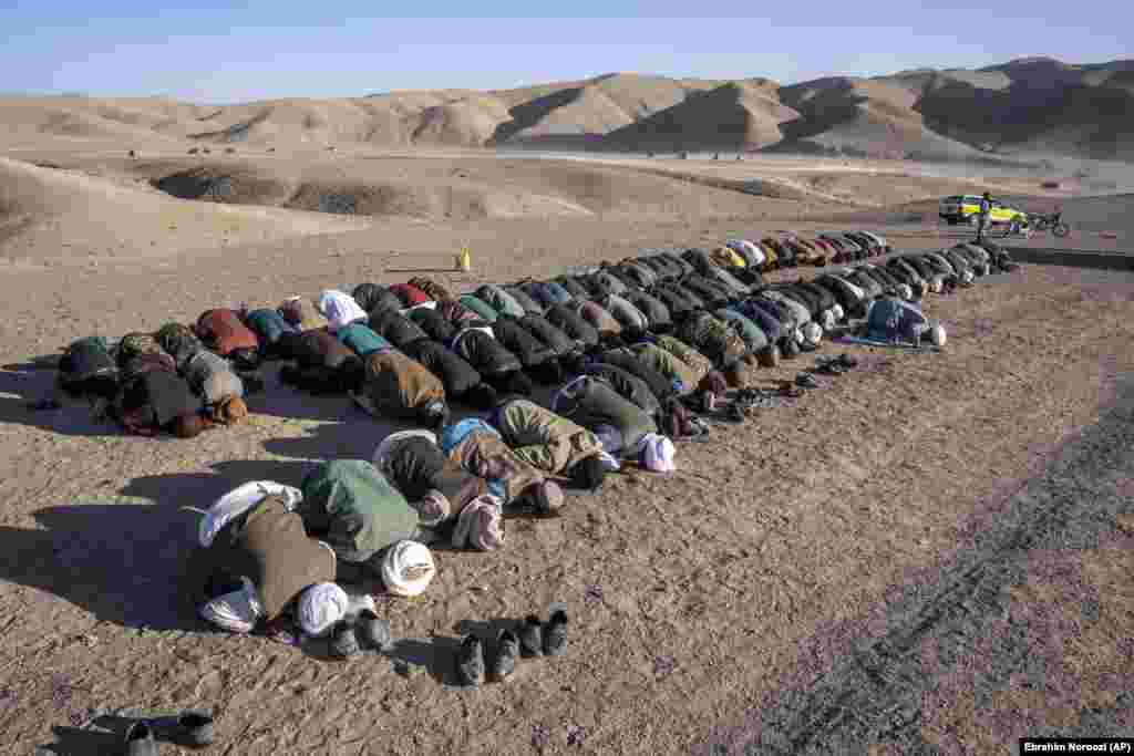 Afghans pray for relatives who were killed in an earthquake at a burial site in Zindah Jan. The rugged area is difficult to reach, and local officials have given conflicting casualty tolls from the series of quakes in the area. On October 8, a member of the Taliban-led government said the updated death toll had surpassed 2,000.
