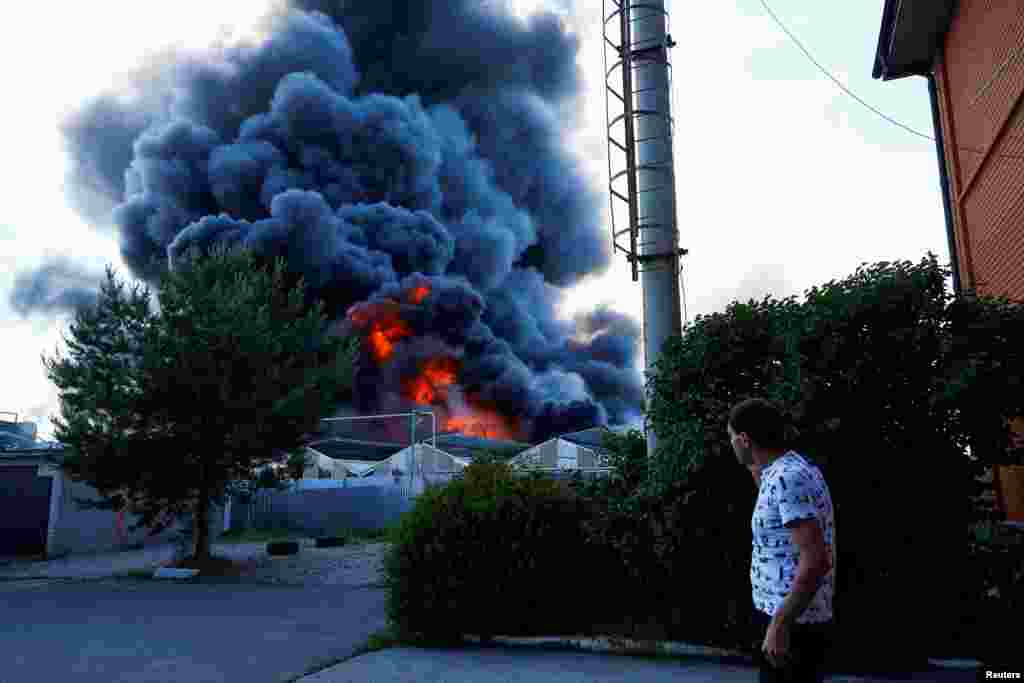 Неподалік місця влучання видно високий стовп густого диму від пожежі