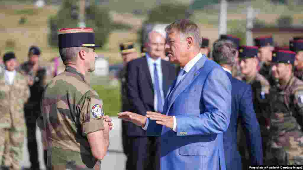 Romanian President Klaus Iohannis speaks with a NATO commander at a base in Cincu, central Romania, on September 5. Iohannis told reporters while visiting the NATO military base, “I can tell you that no part of any drone or any other part of any other device landed in Romania. We have total control over our territory," adding, “I checked absolutely everything and I can reassure the population."