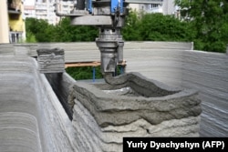 O duză așează amestecul de beton pe șantierul din Liov.