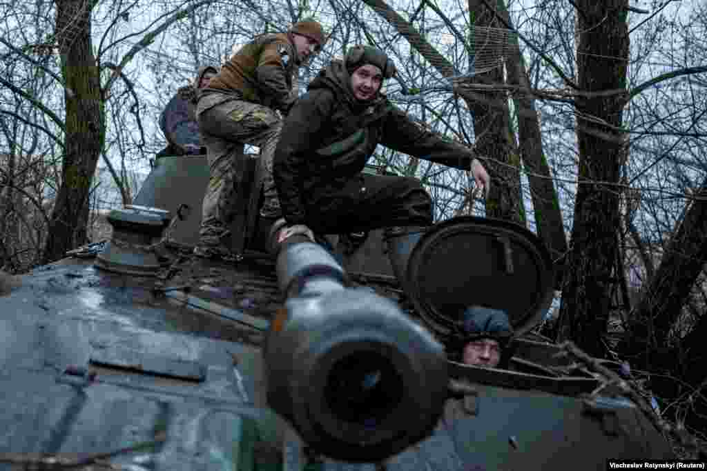 Ukrainian soldiers board 2S1 Gvozdika self-propelled howitzer before it moves into a firing position. 