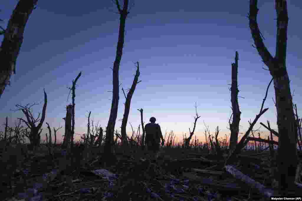 A Ukrainian soldier walks through the charred forest at the front line a few kilometers from Andriyivka. Ukrainian officials said this month’s battle’s for the road to Bakhmut may have taken as many as three Russian brigades out of combat. Neither side has released casualty figures. 