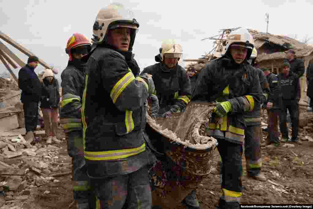 Rescue workers look for survivors amid the rubble of a residential building that was hit by a Russian missile strike in the western city of Lviv. At least four people were reported killed.