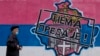 Čovek prolazi pored grafita koji prikazuje mapu Kosova i srpski grb i zastavu na kojoj piše: "Nema predaje!", Beograd, 26. april 2023.