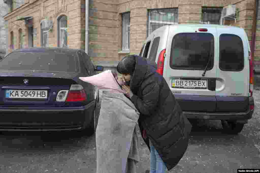 A woman comforts a child.