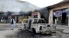 A man looks at charred shops and a vehicle torched by armed separatist group Balochistan Liberation Army (BLA) in the central Bolan district of Balochistan Province on January 30.