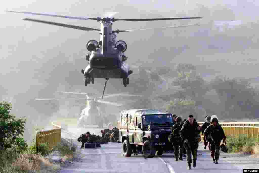 Soldați britanici coboară dintr-un elicopter pe un pod din orașul Kacanik, în sudul Kosovo, pe 12 iunie 1999. Sute de soldați NATO – inclusiv Gurkha, temuții militari nepalezi, au fost folosiți pentru a securiza podul. În prezent, casele sunt aliniate de-a lungul drumului spre pod, care a fost reconstruit.