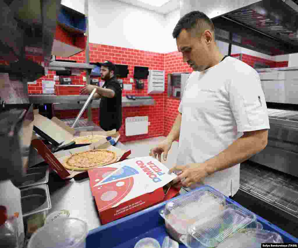 A worker boxes pies in a rebranded Domino's Pizza outlet in Moscow on August 30. In late August, Domino's became the latest major Western brand to exit the Russian market after failing to sell the business. Domino's was the third-largest pizza-delivery chain in the country, with 142 stores. 