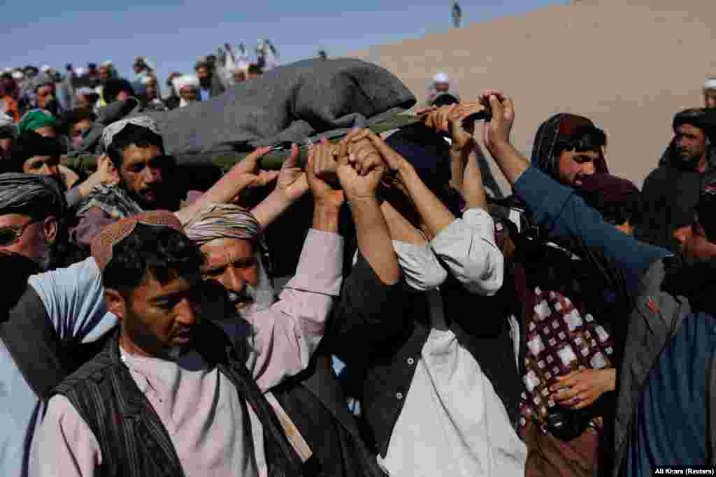 Afghan men carry the body of a woman on October 9 in the district of Zindah Jan. The epicenter of the October 7 quake -- also with a 6.3 magnitude -- was about 40 kilometers northwest of the provincial capital, Herat city. Sources at the local hospital in Herat told RFE/RL that at least one person was killed and 65 others were injured in the new earthquake. 