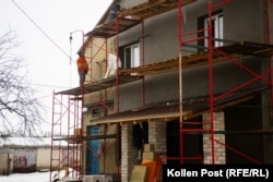 Workers repair a building damaged in the fighting for Yahidne in Ukraine's Chernihiv region.