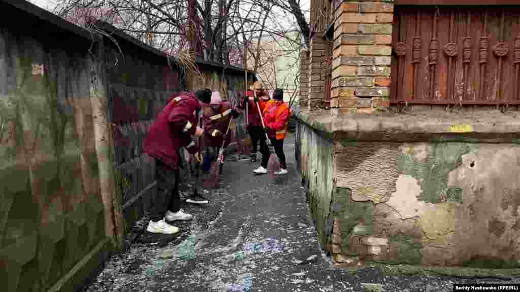 City employees work to clear the debris following the attack near a residential building.