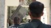 Police officers tear down the DSIT's signboard in Tehran on August 20.