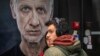 Посетители на изложбата "Чуй гласа ми" в софийската галерия "Missia 23" стоят пред портрет на актьора Иван Бърнев.