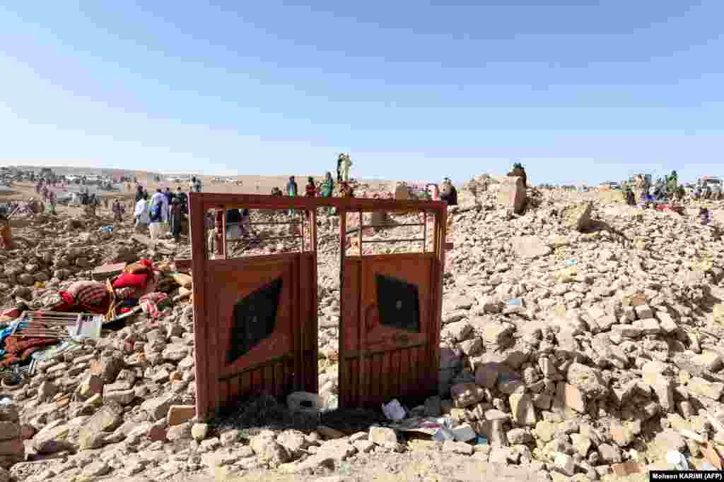 Afghan residents clear debris as they continue their search for bodies in the rubble of homes destroyed during the earthquakes. 