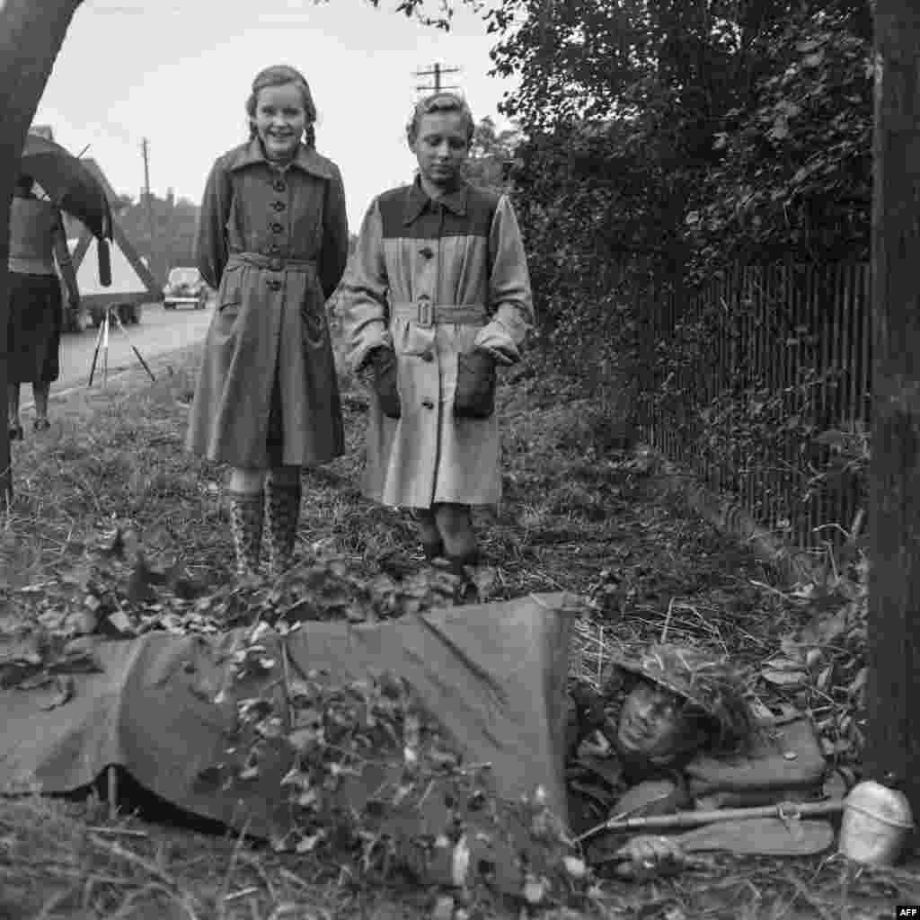 Немецкие девочки наблюдают за британским солдатом во время учений НАТО в 1951 году. Идея трансатлантического военного союза сформировалась после Второй мировой войны, когда СССР, казалось, был готов проложить себе путь через истощённую Европу. В 1948 году Кремль поддержал коммунистический переворот в Чехословакии и начал оказывать давление на Норвегию, чтобы она заключила с Советским Союзом пакт о «ненападении» 