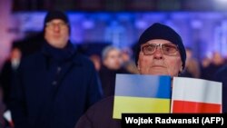Мужчина слушает выступление президента Украины Владимира Зеленского во дворе Королевского замка в Варшаве. 5 апреля 2023 года