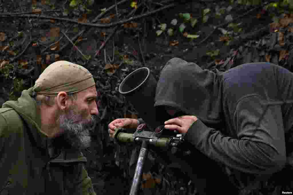Ukrainian soldiers line up their mortar to be fired toward Russian positions. 