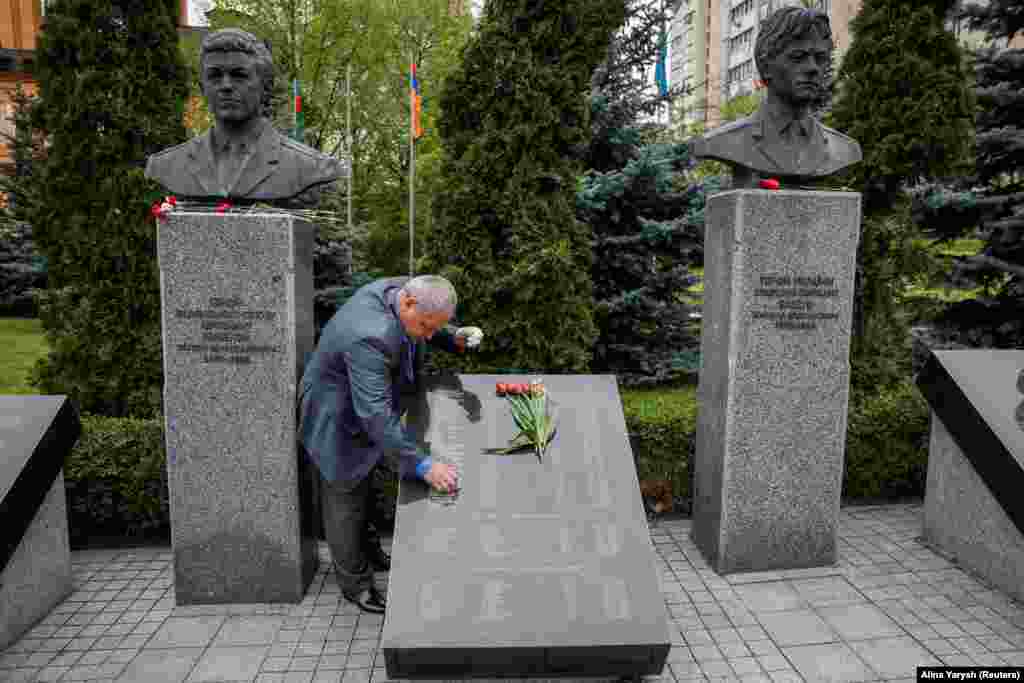 Чоловік чистить табличку з іменами загиблих на ЧАЕС на меморіалі у Києві, 26 квітня 2023 року