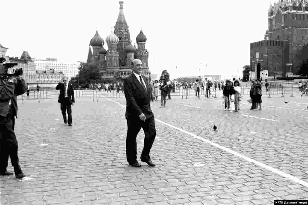 Генеральный секретарь НАТО Манфред Вернер идёт по Красной площади во время визита в Москву в июле 1990 года. Семена нового раскола между Москвой и Западом, по-видимому, были посеяны, когда госсекретарь США Джеймс Бейкер заявил советскому руководству в феврале 1990 года, что «если США сохранят своё присутствие в Германии в рамках НАТО, то ни дюйма существующей военной юрисдикции НАТО не распространится в восточном направлении». Такое же мнение повторил министр иностранных дел Германии Ганс-Дитрих Геншером, хотя эта позиция не документировалась официально