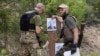 Бійці стрілецького батальйону «Карпатська Січ» готують мішені із зображенням президента Росії Володимира Путіна під час навчань для новобранців на стрільбищі в Харківській області, 30 червня 2022 року