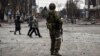 Люди проходять повз російського солдата в центрі Маріуполя, 12 квітня 2022 року (ілюстраційне фото)