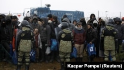 Беларускія памежнікі пільнуюць мігрантаў ля польскай мяжы. Лістапад 2021