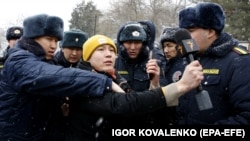 Корреспондент "Азаттыка" в окружении сотрудников милиции во время освещения акции протеста в Бишкеке. Январь 2023 года. 