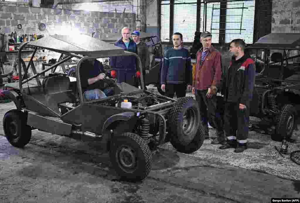 Рабочие у только что собранного багги. Легковесные автомобили высокой проходимости проектируют и изготавливают в мастерской в Кривом Роге. 