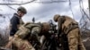 Українські військовослужбовці бригади НГУ «Хартія» заряджають снаряд у гаубицю M101 перед обстрілом російських позицій у Харківській області, 12 березня 2025 року