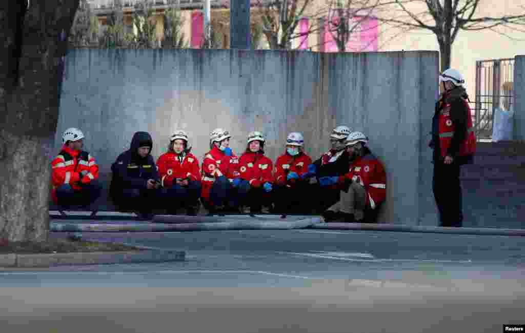 Paramedics take cover in Kyiv as an air-raid siren sounds on February 26.