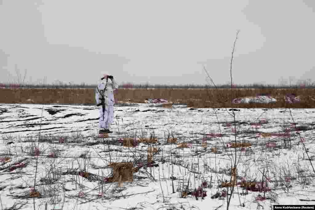 A Ukrainian soldier in snow camouflage peers toward the positions of Russia-backed separatists in the Donetsk region on January 21. 