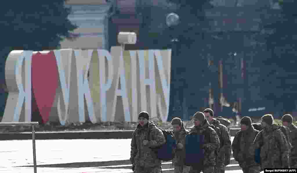 Ukrainian servicemen walk past a sign reading "I Love Ukraine" at Independence Square in Kyiv, the site of large protests in 2014 that led to the ouster of pro-Russia President Viktor Yanukovych.