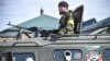 Боец от чеченските специални части се показва от бронетранспортьор с лика на Ахмад Кадиров, бащата на настоящия лидер на Чечня Рамзан Кадиров. Снимката е архивна.