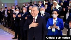 The amendments to the constitution will "nullify" the previous and current terms of Uzbek President Shavkat Mirziyoev (center), allowing him to run for another two consecutive terms. (file photo)